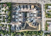 Thumbnail 1 of 14 - A bird's eye view of a residential area with a large open space in the middle.