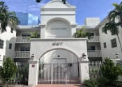 Thumbnail 4 of 12 - a white building with a gate and a palm tree