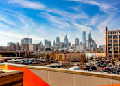 Thumbnail 24 of 29 - A city skyline is visible in the distance behind a parking lot.
