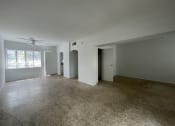 Thumbnail 11 of 12 - an empty living room with white walls and a ceiling fan