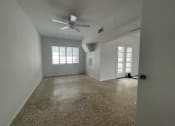 Thumbnail 10 of 12 - the living room of an empty house with a ceiling fan