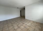 Thumbnail 6 of 12 - the living room and dining room of an empty house with tile flooring