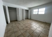 Thumbnail 7 of 12 - an empty living room with a window and two closets
