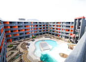Thumbnail 36 of 51 - A large outdoor pool surrounded by a building.