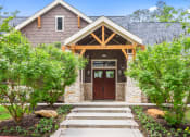 Thumbnail 20 of 24 - the front of a house with a wooden door and stone facade