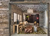 Thumbnail 9 of 20 - A modern living room with a stone wall and a patterned ceiling.