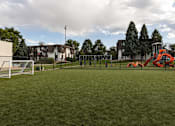 Thumbnail 31 of 42 - A playground with a red slide and a soccer goal.
