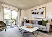 Thumbnail 18 of 42 - A living room with a grey couch, a green chair, and a painting of horses on the wall.