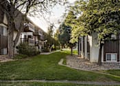 Thumbnail 41 of 42 - A tree-lined pathway leads to apartment buildings.