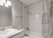 Thumbnail 15 of 42 - A white bathroom with a sink, toilet, and shower.