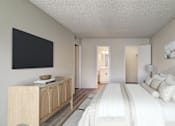 Thumbnail 11 of 42 - A bedroom with a large bed, a wooden cabinet, and a painting on the wall.