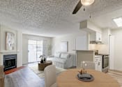 Thumbnail 7 of 42 - Aurora, CO Apartments – Ivy Crossing – A modern living room with a fireplace and a dining table set for two.