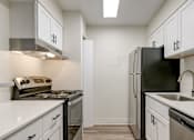 Thumbnail 5 of 42 - A kitchen with white cabinets and black appliances.