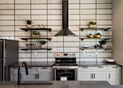 Thumbnail 37 of 42 - A modern kitchen with a black range hood and a black faucet.