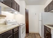 Thumbnail 23 of 42 - A kitchen with white appliances and brown cabinets.
