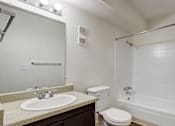 Thumbnail 26 of 42 - A white bathroom with a sink, toilet, and bathtub.