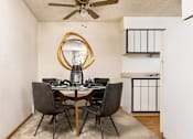 Thumbnail 19 of 42 - Aurora, CO Apartments – Ivy Crossing – A dining room with a round mirror and a table with chairs.