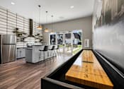 Thumbnail 3 of 42 - A modern kitchen with a shuffleboard table in the middle.