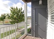 Thumbnail 16 of 26 - A balcony with a white railing and a grey door.