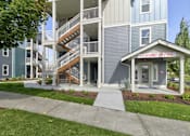 Thumbnail 24 of 26 - A leasing office is located on the ground floor of a two-story apartment building.