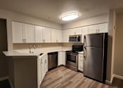 Thumbnail 1 of 16 - A kitchen with a refrigerator, oven, and microwave.