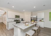 Thumbnail 14 of 35 - A kitchen with a counter and stools.