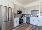 Thumbnail 1 of 13 - Luxury Atlanta, GA Homes – LaFrance Square – A kitchen with a stainless steel refrigerator and white cabinets.