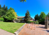 Thumbnail 26 of 30 - Three-Bedroom Apartments in Issaquah, WA - Langara - Playground with Woodchip-Covered Ground, Swing, and Climbing Structures