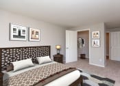 Thumbnail 3 of 30 - 3-Bedroom Apartments in Issaquah, WA - Langara - Bedroom with Carpet Flooring, Full Size Bed, Nightstand with Lamp, Framed Wall Art, and Large Closet.
