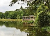 Thumbnail 4 of 12 - Affinitee at Pine Lake Apartments in Pine Lake, GA photo of a house on the shore of a lake