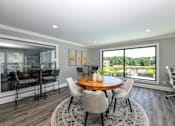 Thumbnail 13 of 17 - A dining room with a round wooden table surrounded by chairs.