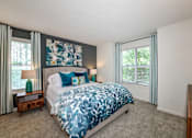Thumbnail 17 of 17 - A bedroom with a large bed and a painting above it.