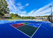 Thumbnail 7 of 17 - A tennis court with a blue surface and white lines.