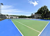 Thumbnail 6 of 17 - A tennis court with a blue surface and white lines.