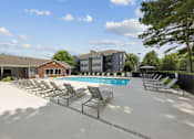 Thumbnail 9 of 25 - Spacious pool deck with lounge seating at Lancaster Place Apartments in Calera, Alabama offering outdoor relaxation and community amenities.