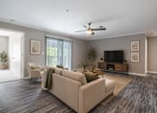 Thumbnail 5 of 25 - Bright open-concept living room at Lancaster Place Apartments in Calera, Alabama featuring wood-style flooring, abundant natural light, and a spacious layout.