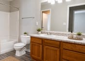 Thumbnail 7 of 25 - Modern apartment bathroom at Lancaster Place Apartments in Calera, Alabama with an oversized vanity, full bathtub, and updated fixtures.