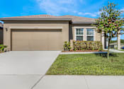 Thumbnail 5 of 63 - A house with a brown garage door and a driveway.