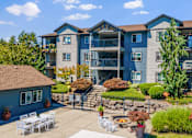 Thumbnail 18 of 18 - A large apartment complex with a patio and outdoor furniture.