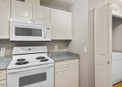 Thumbnail 19 of 30 - a kitchen with white appliances and white cabinets