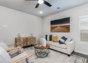 Thumbnail 10 of 39 - 3-BR Homes for Rent in Katy, TX - Villas at Sunterra - Living Room with a Couch, Two Chairs, a Coffee Table, a Ceiling Fan, Wood-Style Flooring, a Window, and Stylish Decor