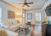 Thumbnail 15 of 33 - Living room with wood floors and couches and chairs and windows with blinds and ceiling light/fan