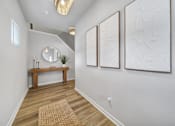 Thumbnail 4 of 19 - Hallway in Indian Trail, NC townhome with vinyl plank wood flooring, bench, mirror, and framed wall art