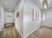 Thumbnail 5 of 19 - Hallway in Indian Trail, NC townhome with vinyl plank wood flooring, bench, and framed pictures