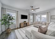 Thumbnail 7 of 19 - Living room in Indian Trail, NC townhome with beige couch, television, ceiling fan, and vinyl plank wood flooring