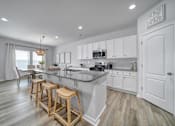 Thumbnail 1 of 19 - Spacious kitchen with island, stainless steel appliances, and granite countertops in Indian Trail, NC townhome