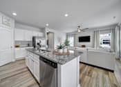 Thumbnail 6 of 19 - Modern kitchen in Indian Trail, NC townhome with granite countertops, stainless steel appliances, island, and open view to living room