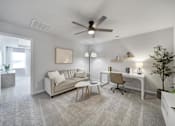 Thumbnail 10 of 19 - Spacious living area with couch, chair, desk, and vinyl plank flooring in Indian Trail townhome