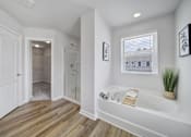 Thumbnail 14 of 19 - Bright bathroom with large soaking tub and window in Indian Trail pet-friendly townhome
