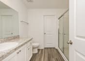 Thumbnail 48 of 75 - A white bathroom with a sink, toilet and a door.